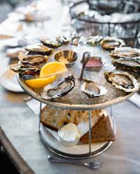 The Walrus and the Carpenter signature dishes A daily selection of fresh oysters, Steak Tartare, and Scallop Crudo.